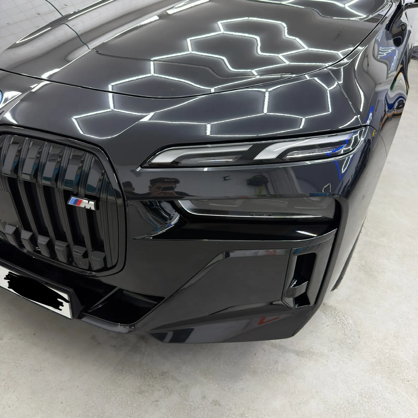 Vyleštěné BMW řady 7 s odlesky šestiúhelníkových světel v našem studiu